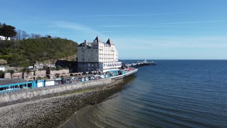 Aerial-view-of-The-Grand-hotel-landmark-Llandudno-seafront-seaside-Victorian-promenade-tourism-building-rising-shot