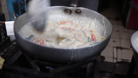 Professional-chef-prepares-white-sauce-Pasta-at-a-street-food-shop-at-Chat-Gali-in-Agra,-India-on-07-March-2021