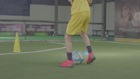 Joven-Entrenando-Fútbol-Con-Pelota-En-Campo-De-Fútbol-Sintético