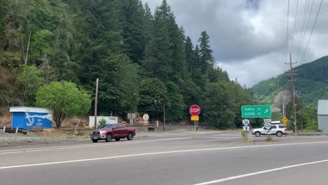 Weitwinkelaufnahme,-Autos-Fahren-An-Einem-Schild-Für-Veneta-Und-Eugene-Im-Ländlichen-Oregon-Vorbei