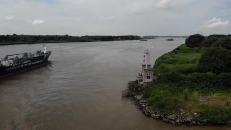 Aerial-View-Of-Speciality-Oil-Tanker-Passing-Coastal-Radar-Tower-In-Barendrecht