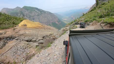 POV-Desde-La-Azotea-De-Un-Vehículo-Jeep-4x4-Siguiendo-Otro-Jeep-En-El-Sendero-Black-Bear-Pass-A-Lo-Largo-De-Ingram-Creek-En-Lo-Alto-De-Telluride,-Colorado