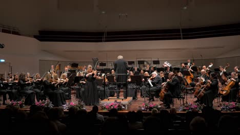 Músicos-Profesionales-De-La-Orquesta-Sinfónica-De-Liepāja-Tocando-En-Un-Concierto-De-Apertura-De-Temporada,-Sala-De-Conciertos-Gran-ámbar,-Plano-Amplio,-Inclinado-Hacia-Abajo,-Revelar