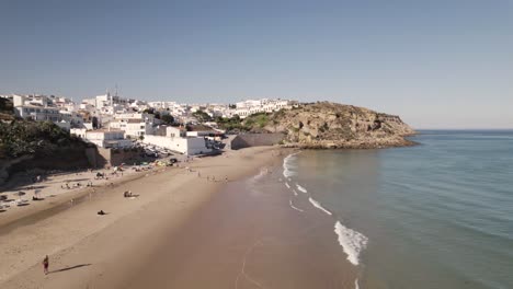 Gente-En-La-Playa-De-Arena-De-Burgau-Disfrutando-De-Las-Pequeñas-Olas-Del-Océano-Y-El-Sol