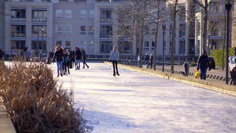 Kinder-Laufen-Auf-Einem-Zugefrorenen-Teich-Schlittschuh-Und-Haben-Spaß-In-Zeitlupe