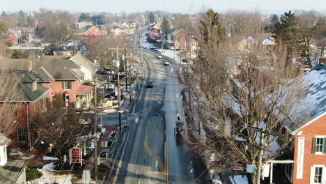 AERIAL-Amish-Horse-And-Buggy-Traveling-Downtown-Street-During-Snowfall