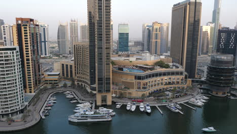 Lujosos-Yates-Atracados-Fuera-Del-Edificio-Del-Centro-Comercial-Dubai-Marina-En-Dubai,-Emiratos-árabes-Unidos