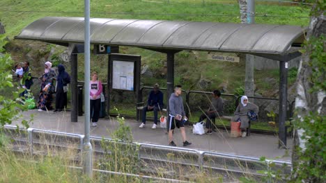 Fixed-cctv-camera-control-in-suburb-of-Gothenburg-city,-People-waiting-for-Tram-in-Bergsjon