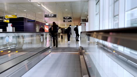 Pasarela-Móvil-En-El-Aeropuerto-De-Munich-Con-Pasajeros-De-Líneas-Aéreas-Caminando