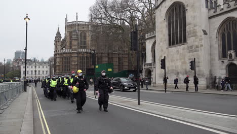 Una-Unidad-De-La-Policía-Antidisturbios-Del-Grupo-De-Apoyo-Territorial-Metropolitano-Con-Máscaras-Faciales-Avanza-Y-Se-Detiene-Cerca-De-La-Abadía-De-Westminster