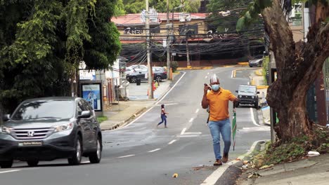 Man-walks-up-a-street-wearing-a-face-mask-and-shield,-COVID-19,-Panama-City,-Panama