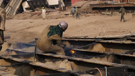 Trabajador-Masculino-Usando-Soplete-De-Acetileno-Para-Cortar-Metal-En-El-Astillero-De-Desguace-De-Barcos-De-Gadani