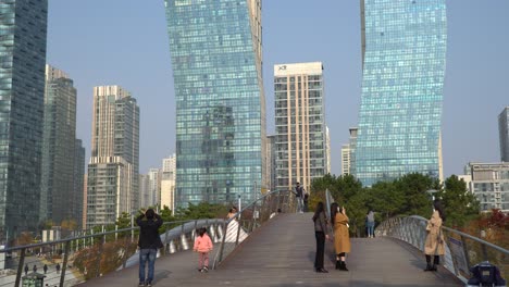 En-Medio-De-Una-Pandemia-Mundial-Y-Con-Máscaras-Faciales,-Los-Coreanos-Cruzan-El-Puente-Peatonal-Para-Visitar-El-Parque-Central-En-Incheon,-Corea-Del-Sur