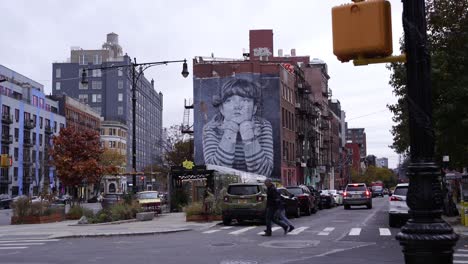 Street-traffic-and-majestic-building-wall-art-in-New-York-City,-dolly-forward-shot