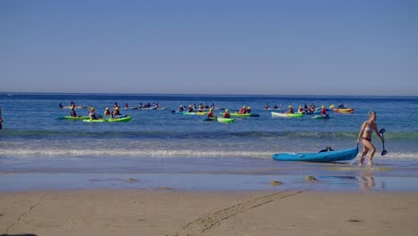 Chica-Tirando-De-Su-Kayak-Por-La-Playa