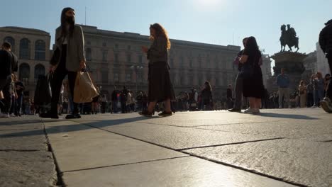 Vista-Frontal-De-ángulo-Bajo-De-La-Gente-Caminando-En-La-Plaza-Del-Duomo-En-Milán-Con-El-Monumento-Ecuestre-Vittorio-Emanuele-Ii-En-El-Fondo,-Italia