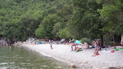 Menschen-Entspannen-Und-Sonnen-Sich-Am-Kiesstrand