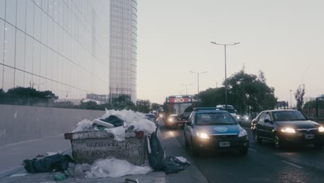 Die-Jüngste-Entwicklung-Des-Paseo-Del-Bajo-Komplexes-Mit-Baumüllcontainern,-Die-Unbeaufsichtigt-An-Der-Seite-Der-Eduardo-Madero-Avenue-Stehen-Gelassen-Wurden,-Was-Zu-Einer-Gefahr-Am-Straßenrand-Während-Der-Hauptverkehrszeiten-Mit-Starkem-Verkehr-In-Der-Abenddämmerung-Führt