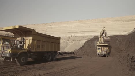 Camión-Volquete-Invirtiendo-En-Mina-A-Cielo-Abierto-En-Pakistán-Con-Excavadora-En-Segundo-Plano.