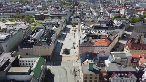 Torgallmenningen-Bergen-Antena-Inversa-En-El-Soleado-Día-De-Verano---Gente-Feliz-Caminando-Debajo---Con-Destello-Solar-E-Inclinación-Hacia-Arriba-Para-Revelar-Una-Hermosa-Vista-Panorámica-De-La-Ciudad-Al-Final---Noruega