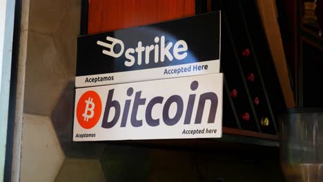 Mittlere-Aufnahme,-Ein-Plakat-Mit-Einem-Bitcoin-Schild,-Das-An-Der-Seite-Der-Wand-Am-Bitcoin-Strand-In-El-Salvador,-Mexiko,-Hängt