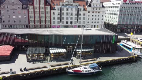 Bergen-fishmarket-aerial-closeup---Rotating-upward-movement-to-reveal-harbor-and-view-byfjord---Aerial-Bergen-Norway