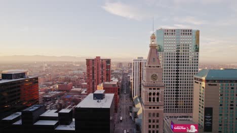 Drohnen-Luftaufnahme,-Die-Durch-Die-Skyline-Der-Innenstadt-Von-Denver,-Colorado,-Fliegt-Und-Lannies-Clocktower-Und-Arapahoe-Street-Während-Des-Sonnenuntergangs-Zur-Goldenen-Stunde-Zeigt