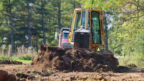 Vista-De-ángulo-Bajo-De-La-Excavadora-John-Deere-560h-Lgp-Empujando-La-Suciedad-En-El-Sitio-De-Construcción-En-La-Zona-Rural-De-Illinois-En-Otoño-Con-Un-Camión-Volquete-En-Segundo-Plano