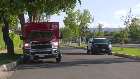 Firetruck-and-police-car-parked-on-the-side-of-a-street-in-sunny-Los-Angeles,-USA