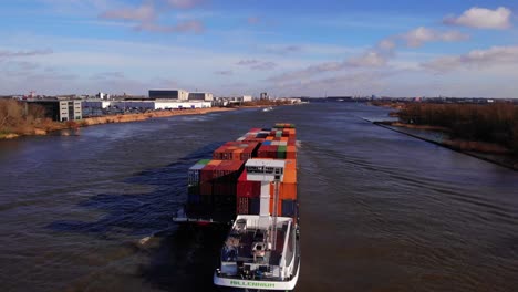 Vista-Aérea-Mientras-Un-Barco-Del-Milenio-Que-Transportaba-Contenedores-De-Carga-Viaja-A-Lo-Largo-De-Oude-Maas