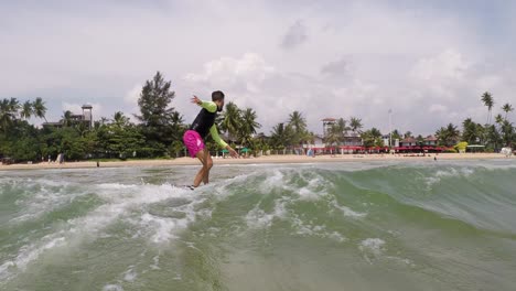 Chico-Atlético-Montando-Olas-En-Tablas-De-Surf-Compitiendo-Con-Sus-Amigos-En-La-Hermosa-Playa-De-Weligama,-Sri-Lanka