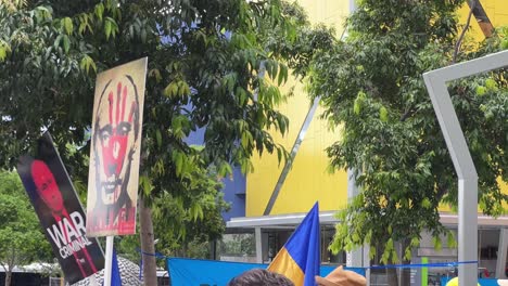 Demonstrators-gathered-at-Brisbane-Square-to-peacefully-rally-against-inhumane-invasion-of-Ukraine-by-the-Russian-military,-protestors-holding-placards-suggesting-that-Vladimir-Putin-is-a-terrorist