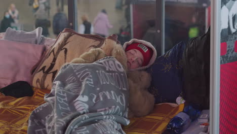 2022-Russian-invasion-of-Ukraine---Central-Railway-Station-in-Warsaw-during-the-refugee-crisis---a-young-girl-is-sleeping-on-the-floor