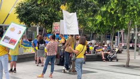 Eine-Frau-Hält-Ein-Banner-Mit-Dem-Herzförmigen-Wappen-Der-Ukraine-Während-Einer-Friedlichen-Pazifistischen-Demonstration-Auf-Dem-Brisbane-Square,-Um-Zum-Frieden-Aufzurufen,-Während-Die-Spannungen-Zwischen-Russland-Und-Der-Ukraine-Zunehmen