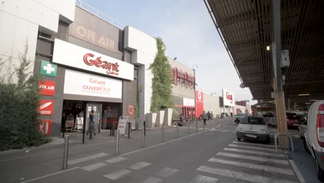 People-entering-Geant-Casino-Supermarket-and-mall,-Dolly-right-slow-motion-shot