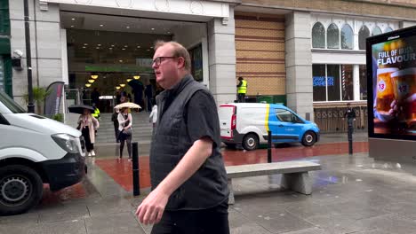 Real-time-shot-of-many-people-in-city-walking-through-central-city-of-Dublin-during-rainy-day