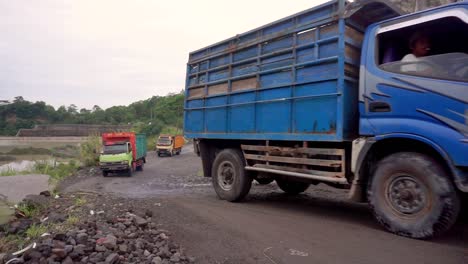 LKW-Und-Motorrad-überqueren-Sandige-Straße,-Um-Sand-Auf-Der-Sandmine-Aufzunehmen