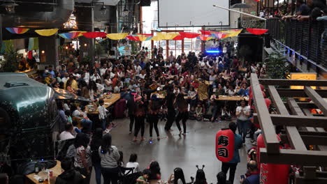 Bailarines-Asiáticos-De-Alta-Energía-Actuando-Para-Animar-A-La-Multitud-Aplaudiendo-En-La-Celebración-Del-Festival-Holi-Cultural-Interior-En-Suecia