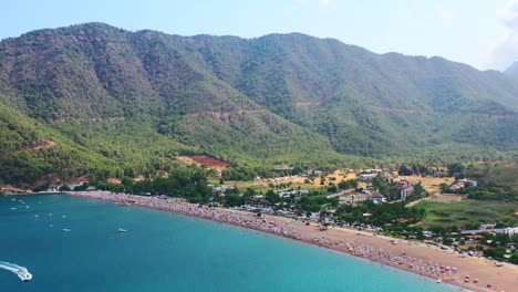 Luftaufnahme-Der-Trockenen-Berglandschaft-Des-Strandes-Von-Adrasan-In-Der-Türkei-An-Einem-Heißen-Sommertag,-Während-Die-Menschen-Den-Tag-Entlang-Der-Mittelmeerküste-Genießen