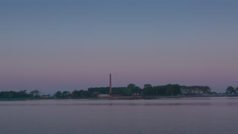 Weitwinkelaufnahme-Des-Schornsteins-Auf-Hart-Island,-Feierliche-Grabstätte-Für-Nicht-Identifizierte-Tote,-Abends-Vom-Wasser-Aus