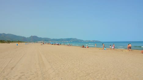 Turistas-En-La-Playa-De-Arena-Blanca-De-El-Grau-Cerca-De-Moncofa,-Castellon-España