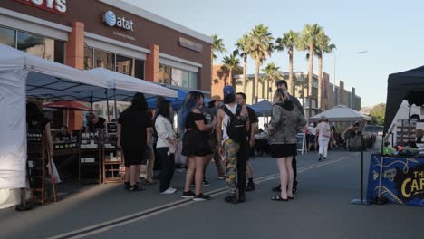 Gente-Parada-En-La-Calle-Por-Vendedor-Al-Aire-Libre-En-Un-Evento-En-San-José,-California