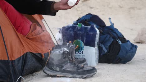 Mano-De-La-Carpa-Para-Dormir-Aplicando-Polvos-De-Talco-A-Las-Botas-De-Montaña