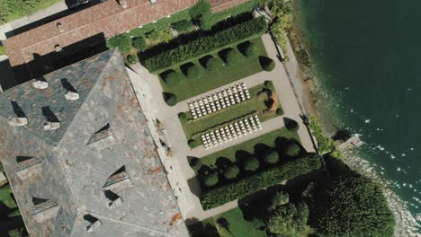 Vista-Aérea-De-Aves-En-El-Patio-Trasero-De-La-Famosa-Villa-Balbiano-En-El-Lago-Como-En-Italia-Mientras-Se-Sienta-Para-Una-Boda-Que-Revela-Un-Bote-En-El-Lago