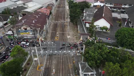 Vista-Aérea,-Tráfico-Pesado-Que-Pasa-Por-El-Cruce-Ferroviario-Adyacente-A-La-Estación-Lempuyangan-De-Yogyakarta