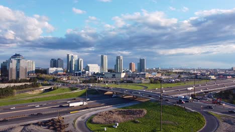 Highway-401-ramp-with-busy-traffic-at-Scarborough-Town-Centre-showing-large-shopping-mall,-big-box-stores-and-condominiums