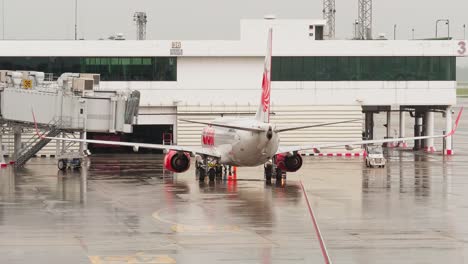 Thai-Lion-Airlines-Docken-An-Der-Halle-An,-Während-Sie-Sich-An-Einem-Regnerischen-Tag-Mit-Bodenpersonal-Auf-Dem-Internationalen-Flughafen-Don-Mueang-dmk-Auf-Den-Abflug-Vorbereiten