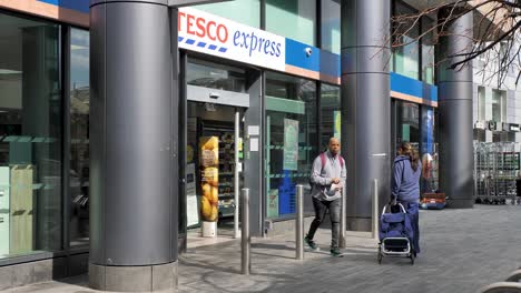 Isle-of-Dogs-England-September-2022-Pan-up-establishing-shot-of-Tesco-Express-exterior