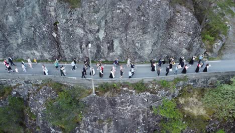 Local-people-walking-in-torchlight-procession-at-evening-during-Norway-constitution-day---Small-countryside-village-Stamneshella-in-Vaksdal-municipality---Aerial-view