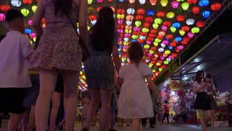 Low-Shot-Of-A-Busy-Street-With-Tourists-Admirning-And-Taking-Photos-Of-The-Amazing-Coloured-Hanging-Lanterns-In-A-Street-In-Lang-Son-City,-Vietnam